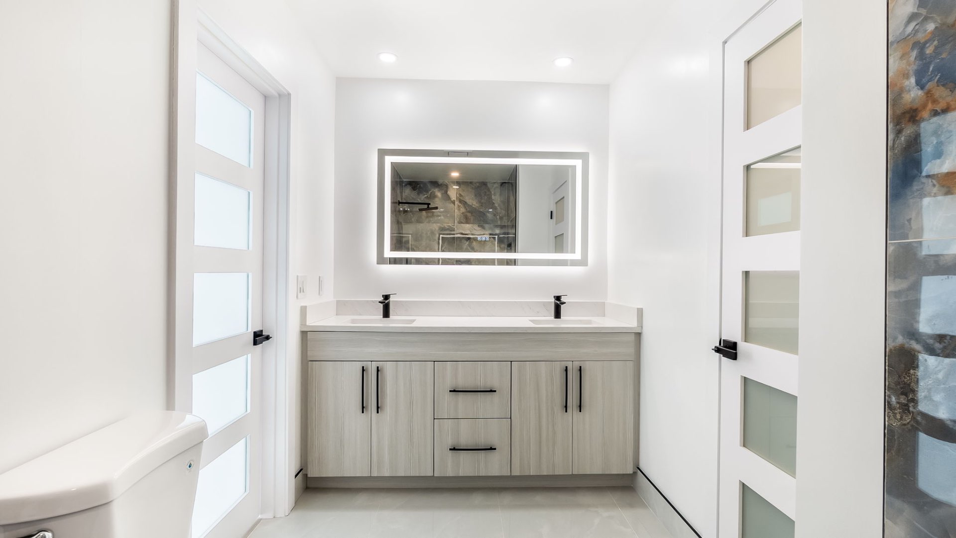 Modern bathroom with dual vanity and LED mirror