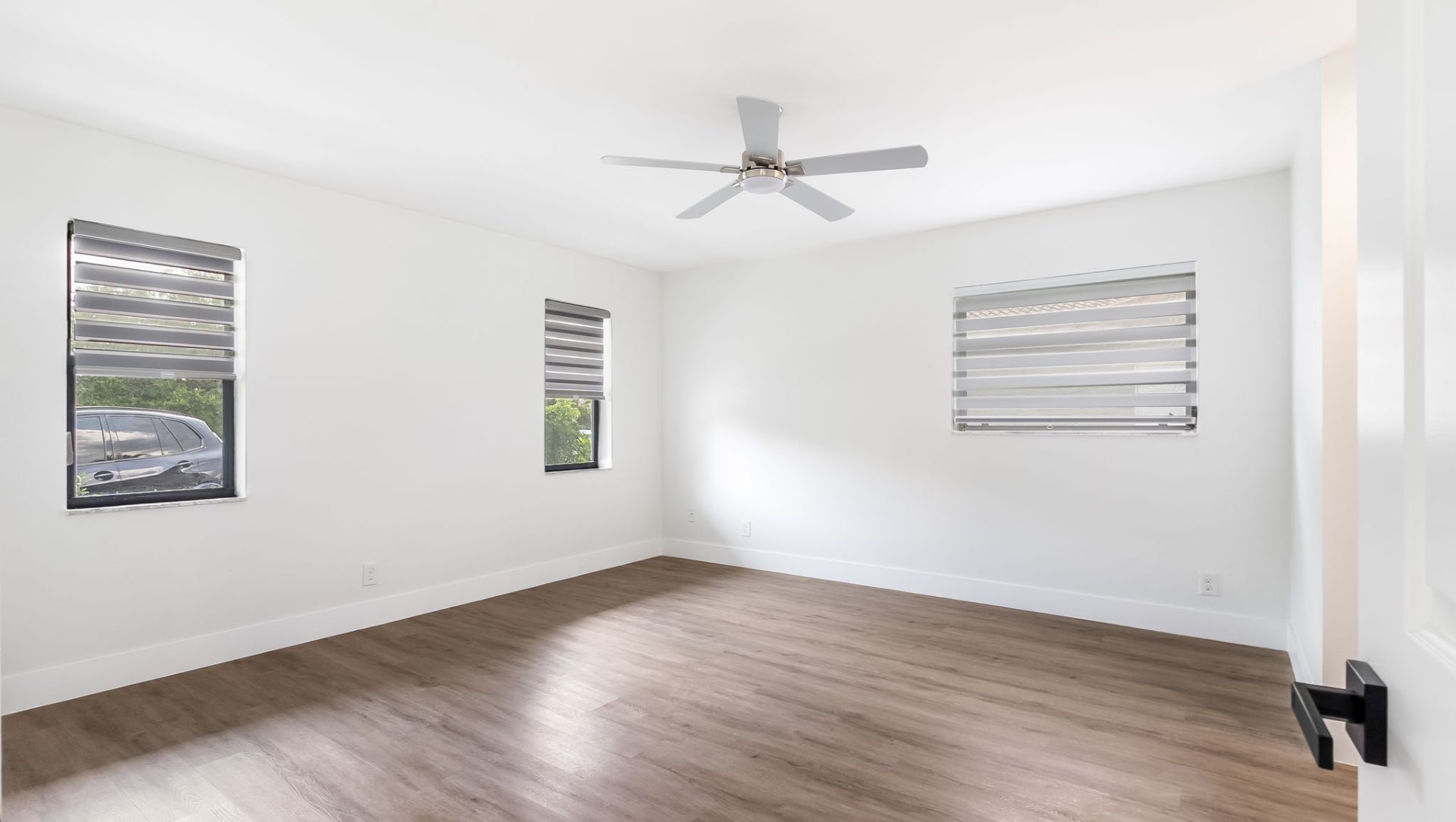 Primary bedroom with wood floors and natural light